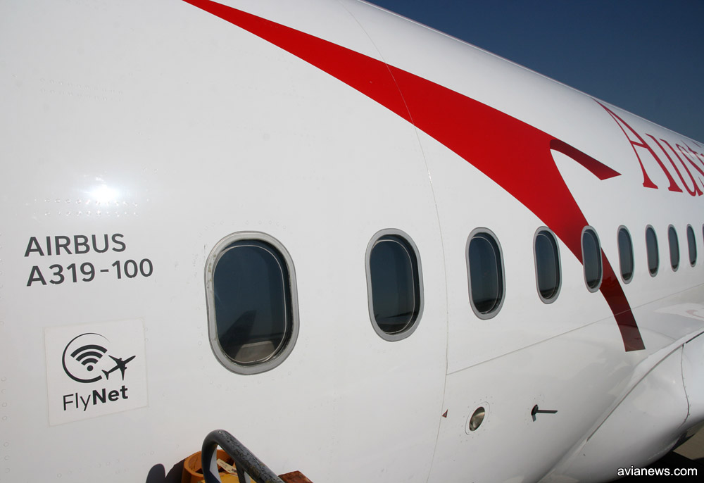 Значок Flynet на входе в самолет Austrian Airlines, который свидетельствует о том, что на борту предоставляется услуга доступа в интернет во время полета
