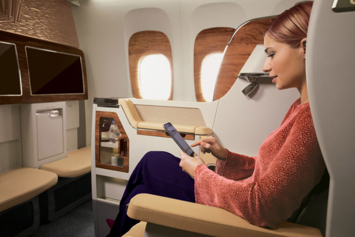 Пассажир Emirates использует телефон для выхода в интернет во время полета