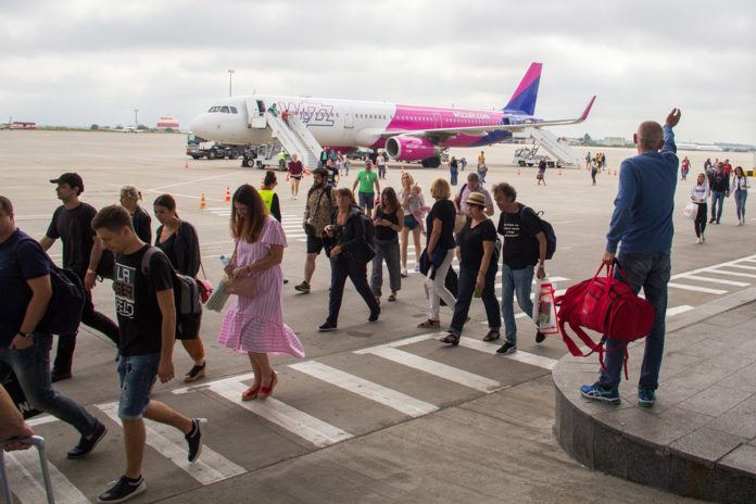 Пассажиры идут по перрону от самолета Airbus A321 Wizz Air