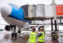 Автоматический сдвоенный телетрап присоединен к Boeing 777 KLM в аэропорту Амстердама Схипхол