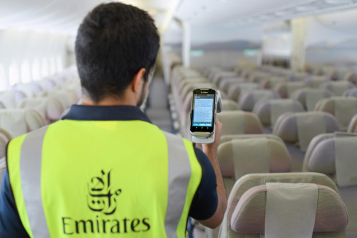 Техник Emirates с помощью сканера проводит считывание информации с RFID-тегов, размещенных на спасательных жилетах в самолете