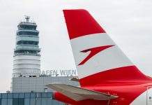 Самолет Austrian Airlines на фоне диспетчерской вышки в аэропорту Вена