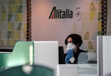 Сотрудник Alitalia на стойке регистрации в аэропорту