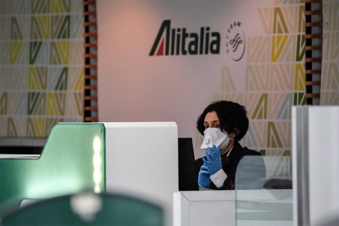 Сотрудник Alitalia на стойке регистрации в аэропорту