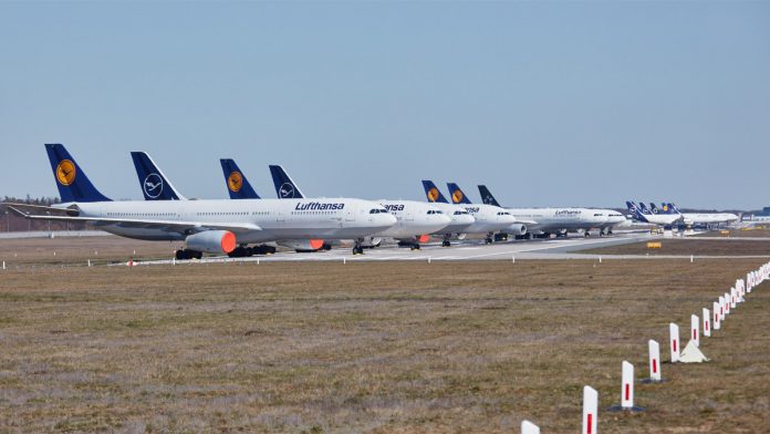 Запаркованные на закрытой взлетно-посадочной полосе самолеты Lufthansa в аэропорту Франкфурта Запаркованные на закрытой взлетно-посадочной полосе самолеты Lufthansa в аэропорту Франкфурта
