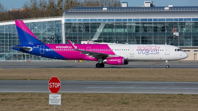 Самолет Wizz Air на фоне знака STOP