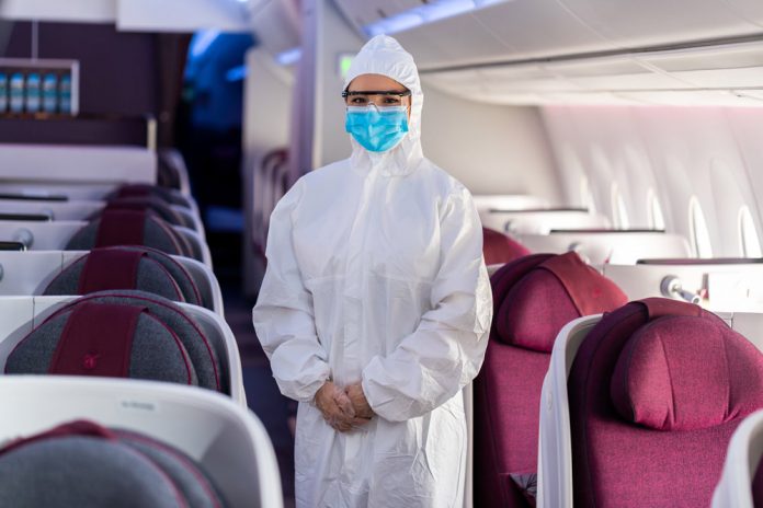 Бортпроводник Qatar Airways в защитном костюме, маске и очках