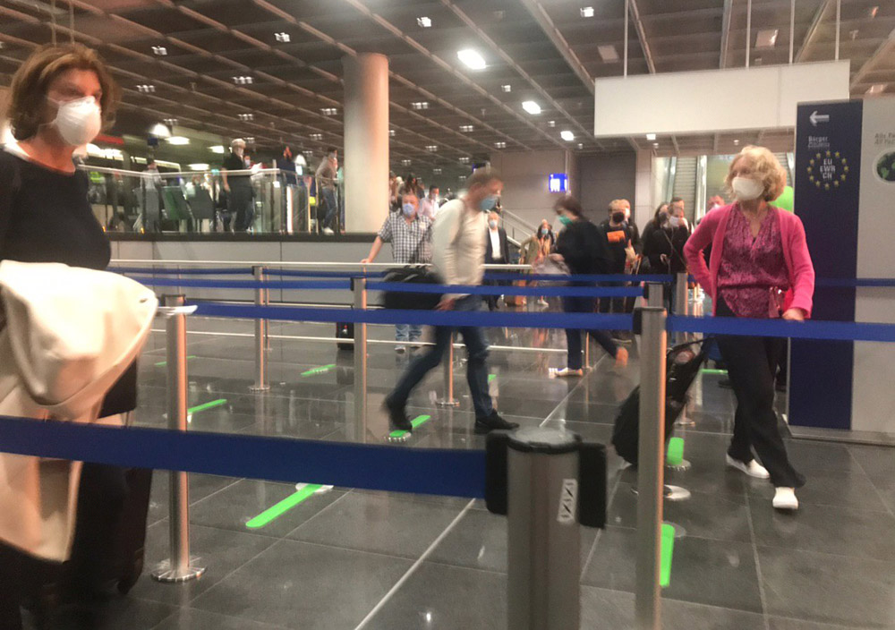 Люди идут на паспортный контроль в аэропорту Франкфурта
