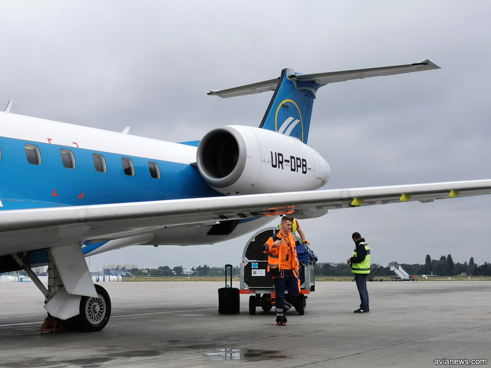 Загрузка большой ручной клади в багажный отсек Embraer 145
