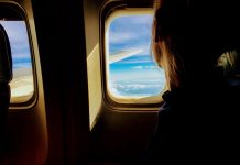 Пасажир дивиться у вікно у літаку