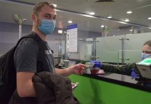 Пассажир в маске проходит паспортный контроль в аэропорту
