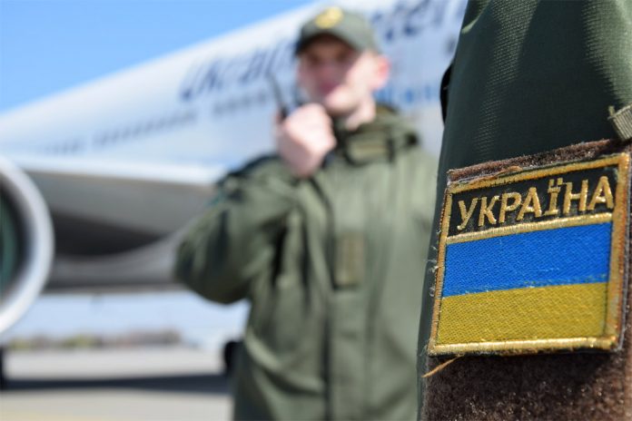 Флаг Украины, пограничник на фоне самолета