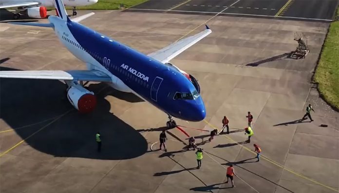 Процесс буксировки самолета Airbus A320 командой из двух женщин