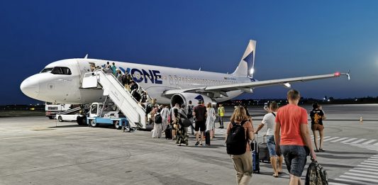 Пасажири йдуть пішки від термінала до літака