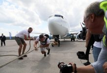 Силач Иннокентий Веселов перетягивает самолет Boeing 737-800 авиакомпании Nordstar в аэропорту Красноярска