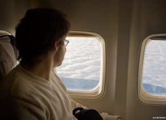 Пассажир в самолете на месте у окна