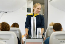 Стюардесса катит тележку с разливным пивом в самолете airBaltic