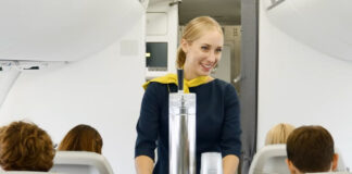 Стюардесса катит тележку с разливным пивом в самолете airBaltic