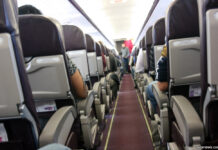 Пассажиры в салоне самолета. Вид из прохода самолета