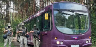 Украинские военные на фоне автобуса из Аэропорта Лутон